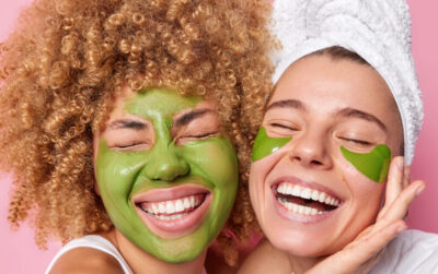 young women having green facial mask beauty treatment